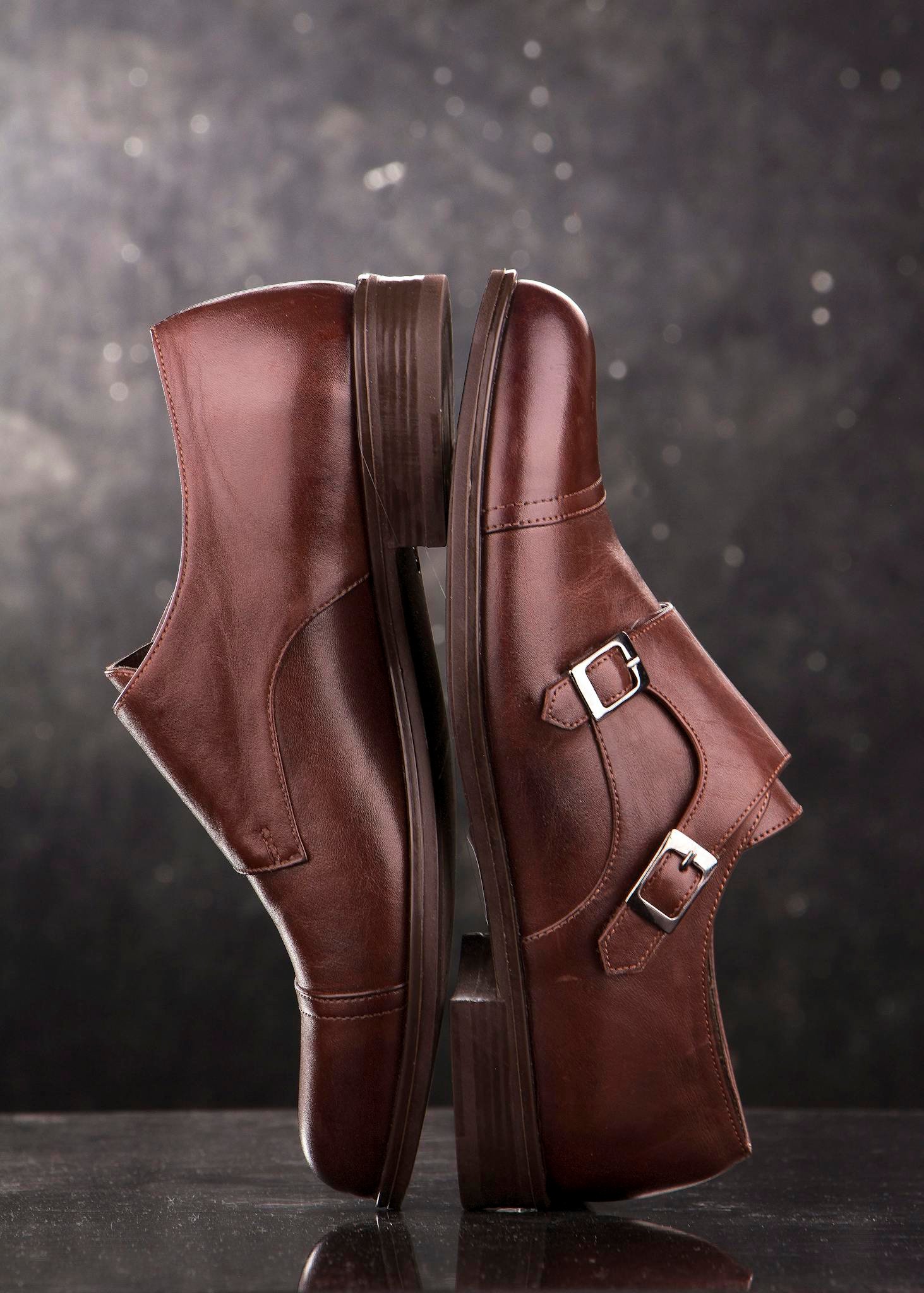 Close-up of elegant brown leather monk strap shoes in studio lighting.
