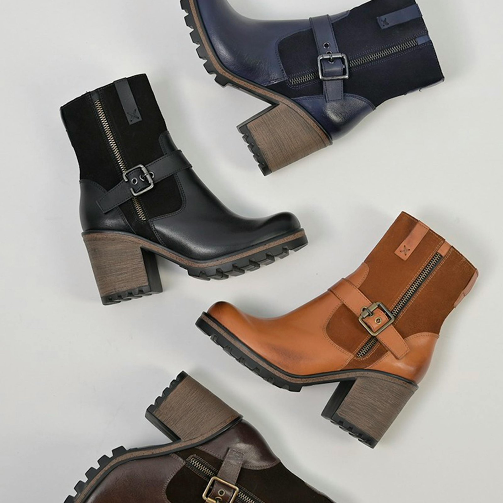 A collection of elegant leather ankle boots arranged in a flat lay on a neutral background.